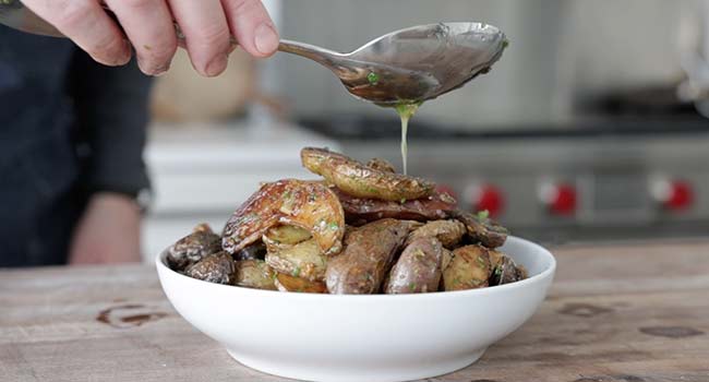 drizzling butter on potatoes