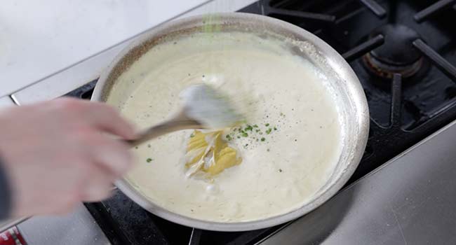 stirring mustard into a pan of cream