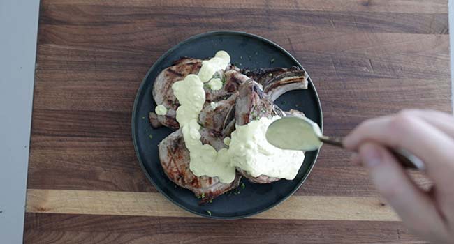 adding the mustard sauce onto pork chops