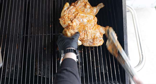 rotating a flattened chicken on the grill