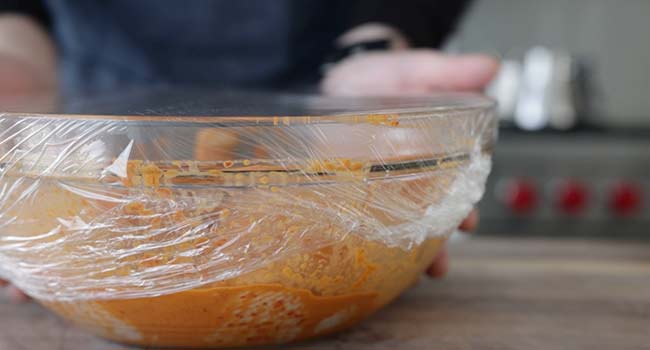 resting a chicken in a bowl with peri peri sauce