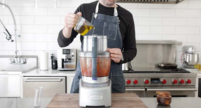 adding oil to a food processor