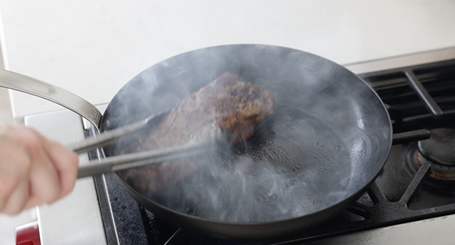 moving a steak around in a pan