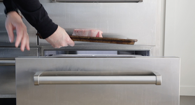 adding a steak to a refrigerator