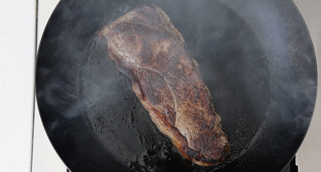 cooking a steak in a pan