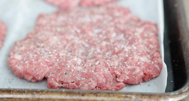 seasoning a burger patty