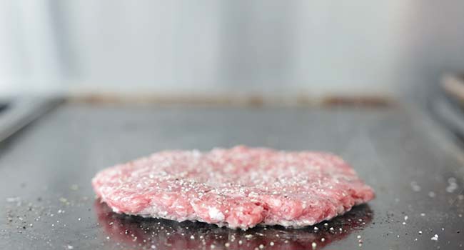 searing a burger patty