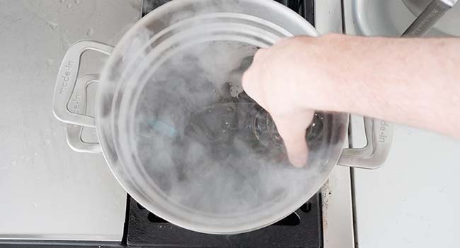 adding lobster to a steamer basket