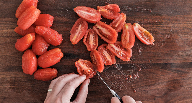 slicing tomatoes in half