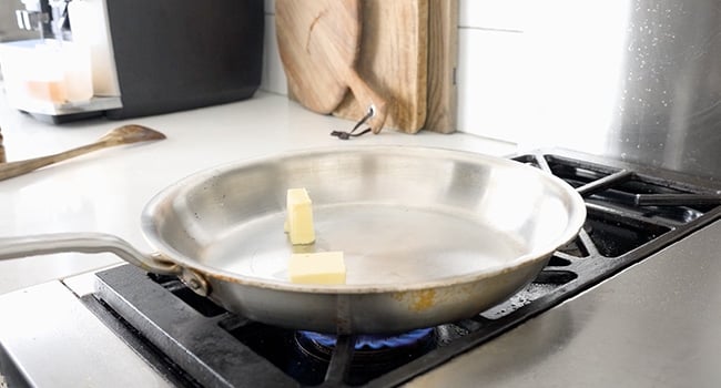 adding butter to a pan