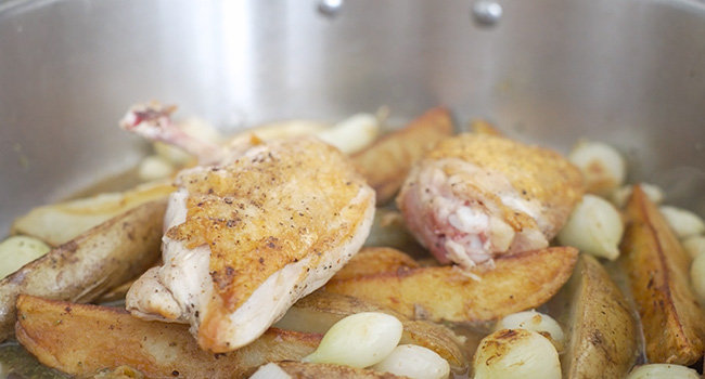 adding chicken and potatoes to a pot