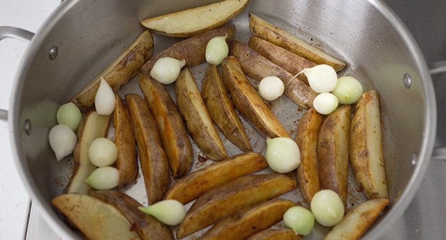 potato wedges and pearl onions in a pot