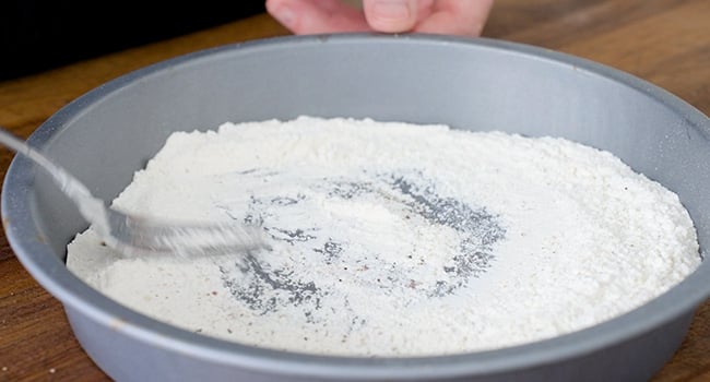 whisking flour in a tin