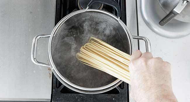 adding spaghetti to boiling water