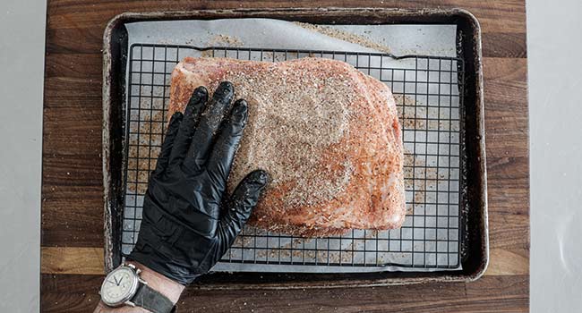 rubbing a pork butt with spices