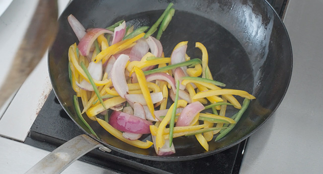 onions and peppers in a pan