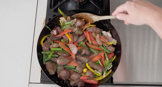 mixing vegetables and beef