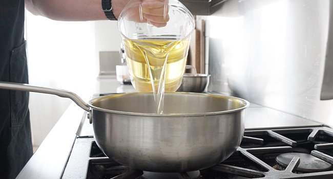 adding oil to a pot