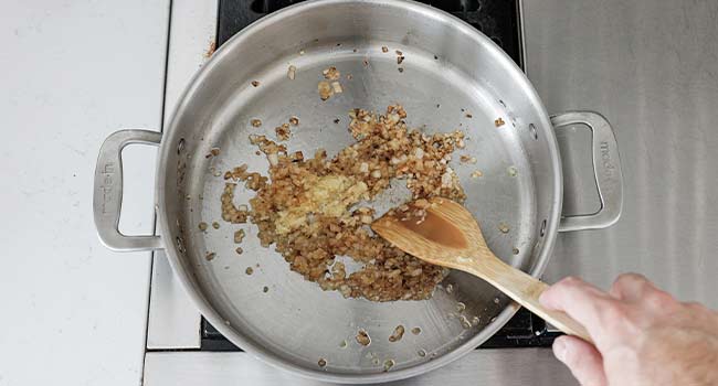 mixing garlic and onions in a pan