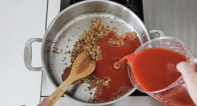 pouring tomato puree to a pan