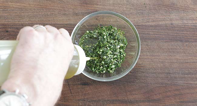 mixing herbs and oil in a bowl