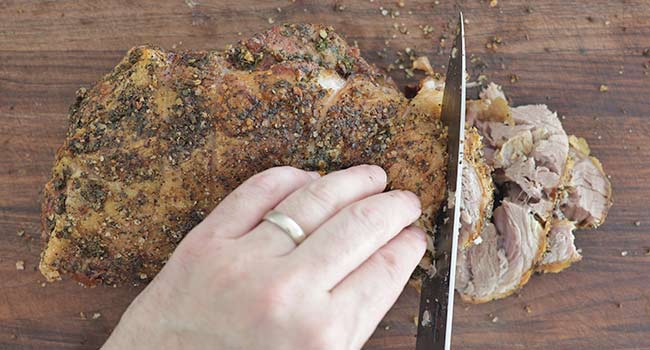 slicing a pork shoulder roast