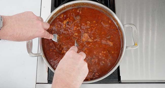 shredding ribs in tomato sauce