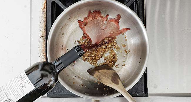 adding wine to a pan