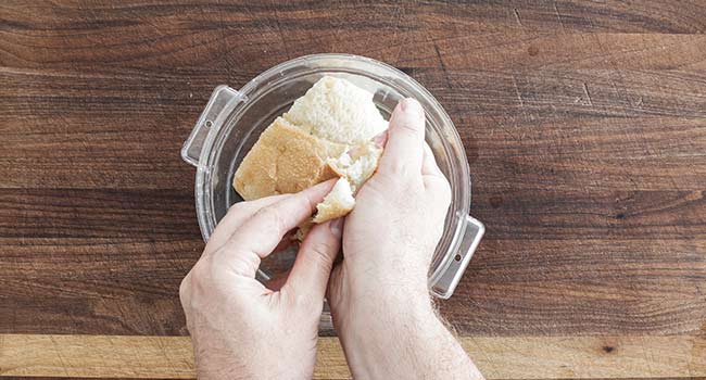 squeezing the water from soaked bread