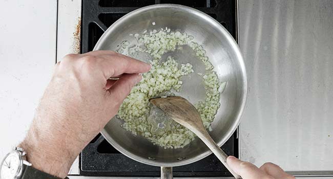 seasoning onions in a pan