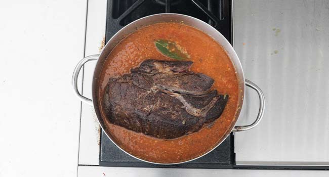 beef, herbs, and gravy in a pot