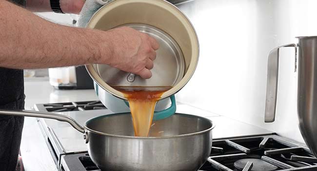 pouring beef stock into a pot