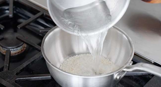 adding boiling water to toasted rice