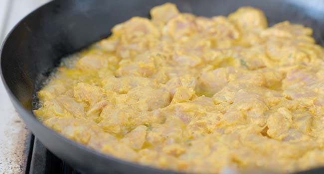 adding chicken tikka masala to a pan