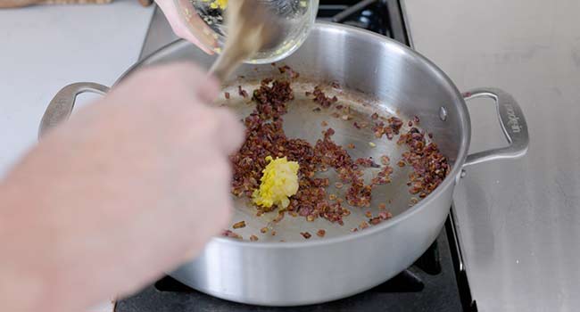 adding ginger to cooked onions