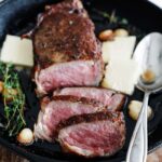 sliced steak in a pan with butter