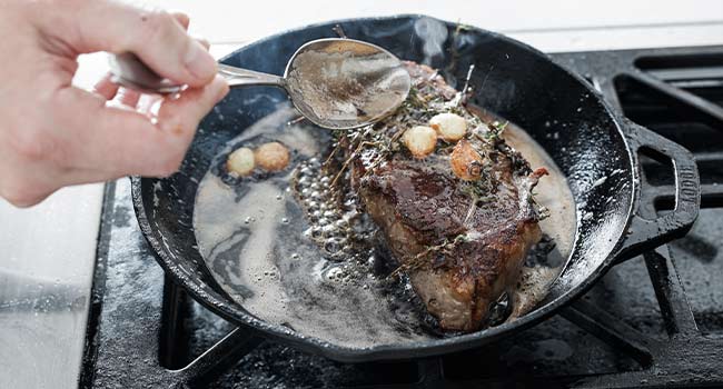 basting a steak with butter