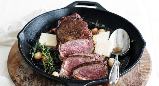 sliced new york strip steak in a pan