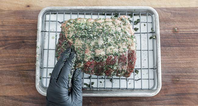 rubbing a beef roast with an herb oil