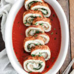 chicken braciole in a dish with tomato sauce