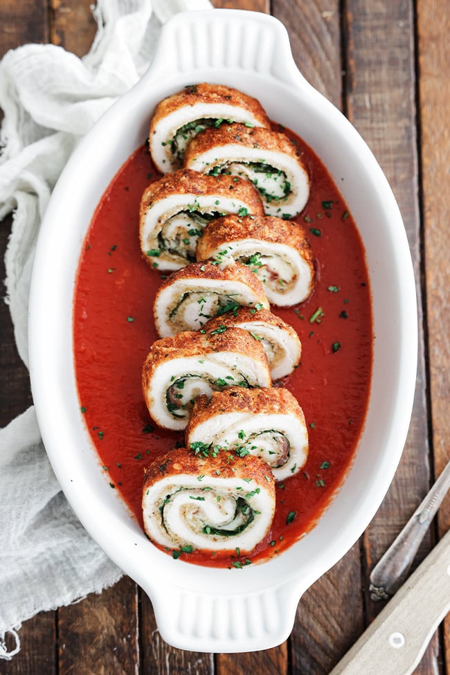 chicken braciole in a dish with tomato sauce