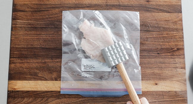 flattening chicken in a plastic bag