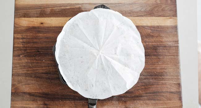 parchment paper round over a cast iron skillet