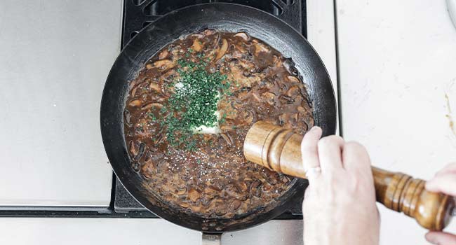 adding parsley and butter to mushroom gravy