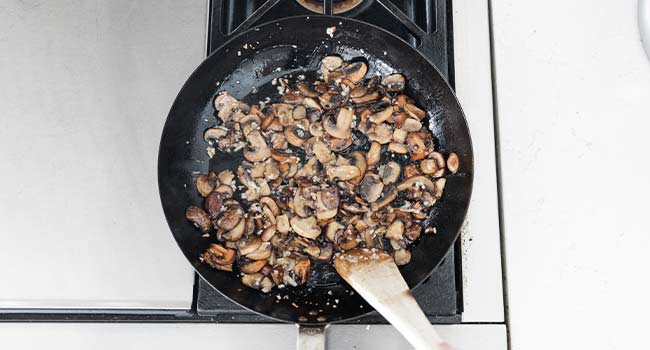 mixing together mushrooms and shallots