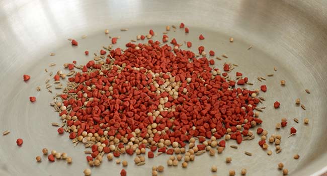 annatto and cumin seeds in a pan