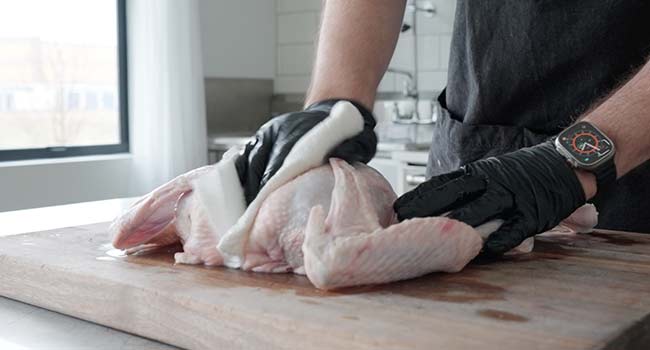 patting a turkey dry with paper towles