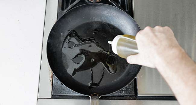 adding oil to a pan