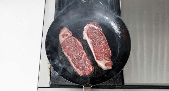 cooking steaks in a pan