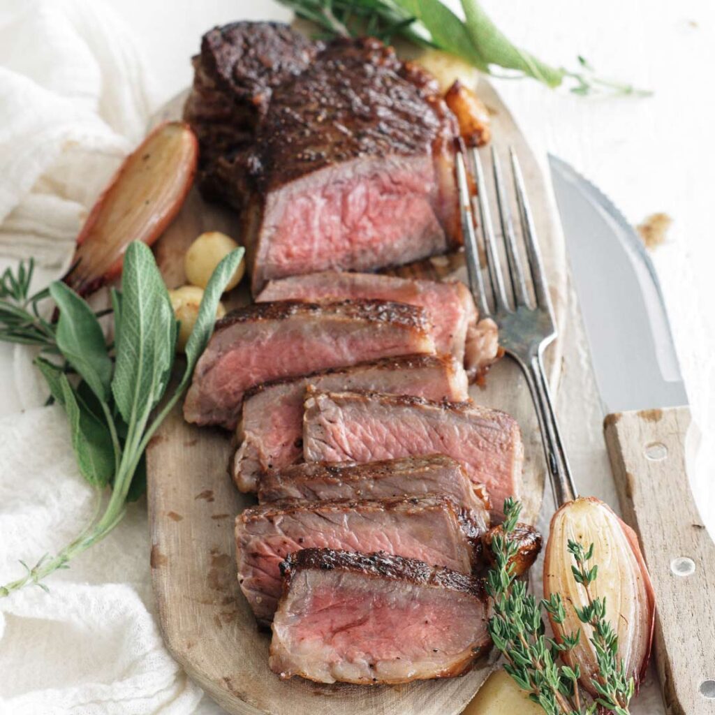 sliced cooked steak on a board